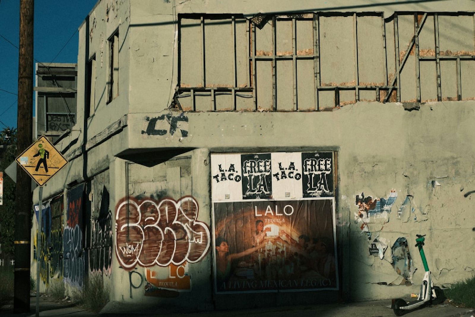 Prédio coberto de grafites e cartazes em cenário urbano