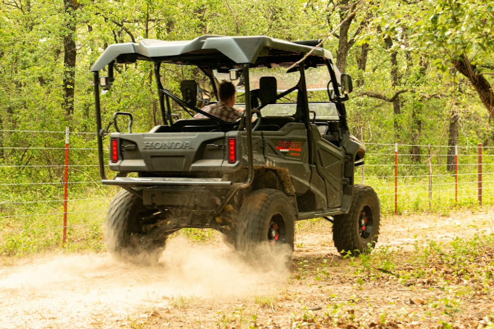 a man driving a four - wheeler on a dirt road